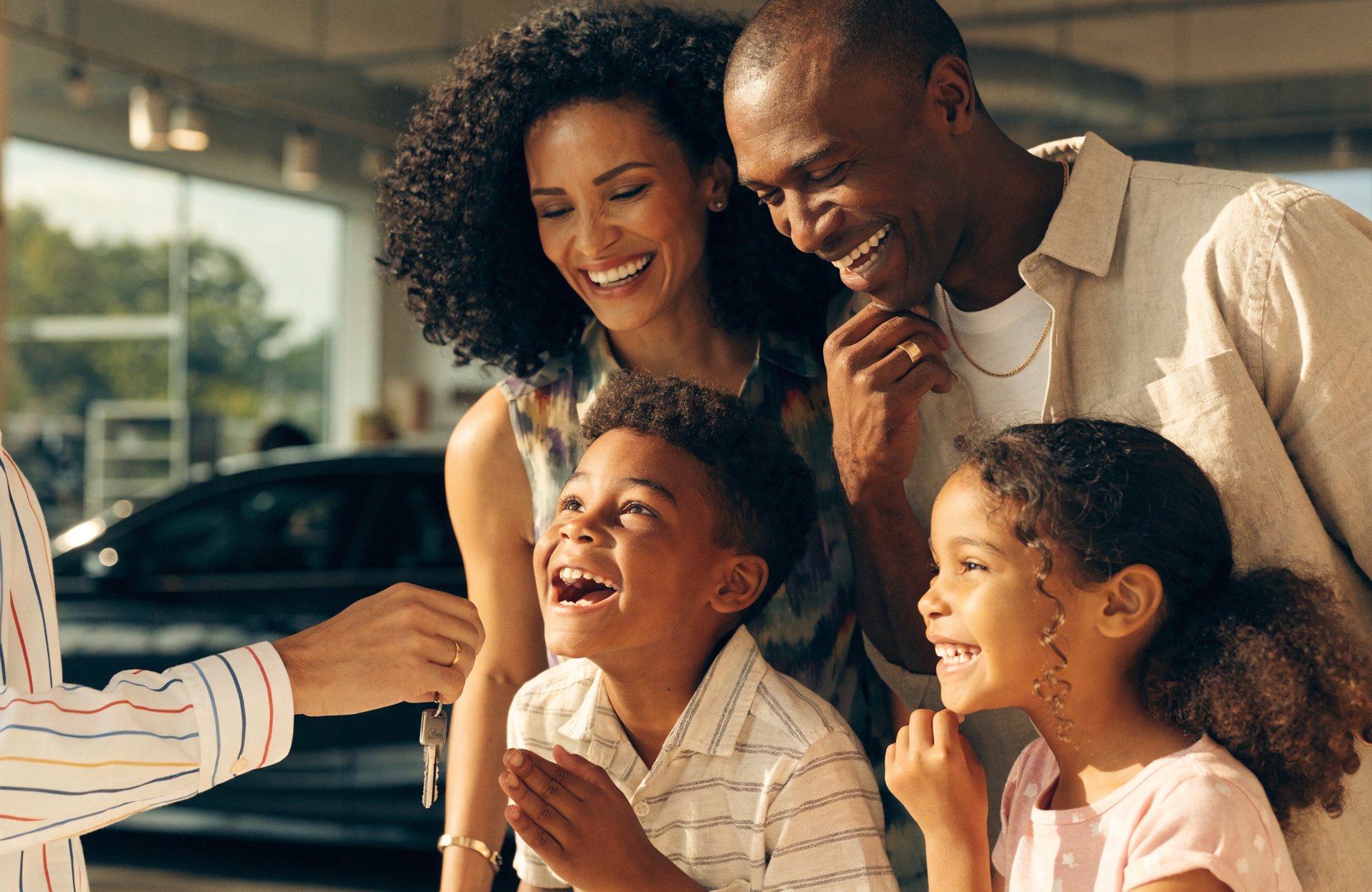 Família feliz recebendo a chave do carro na loja